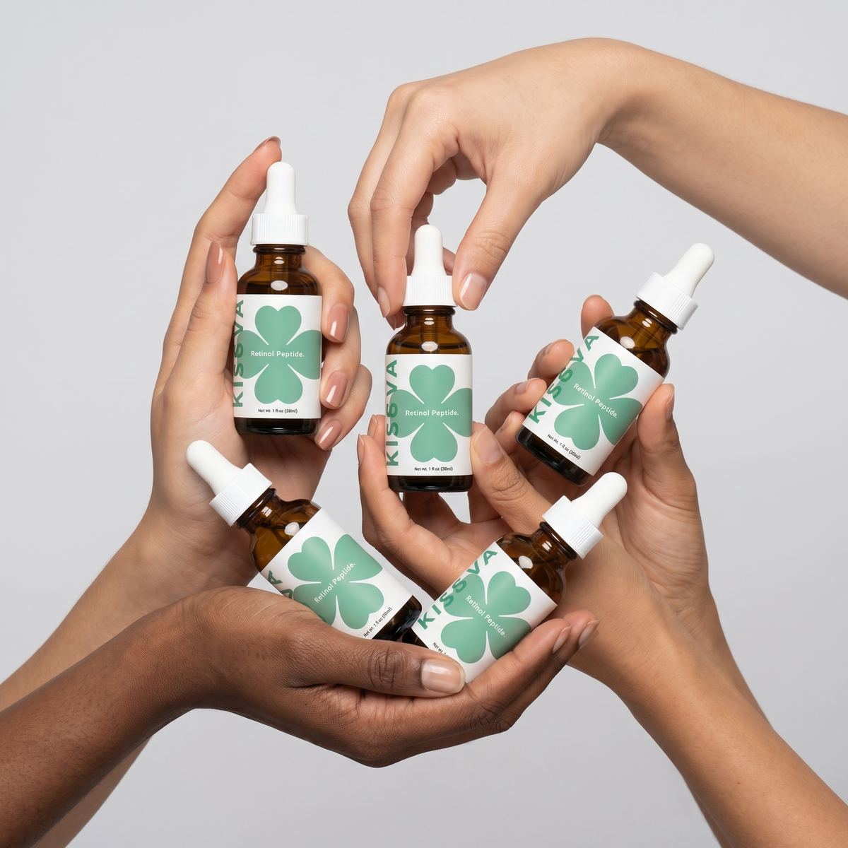 Diverse hands holding Kisuva serums
