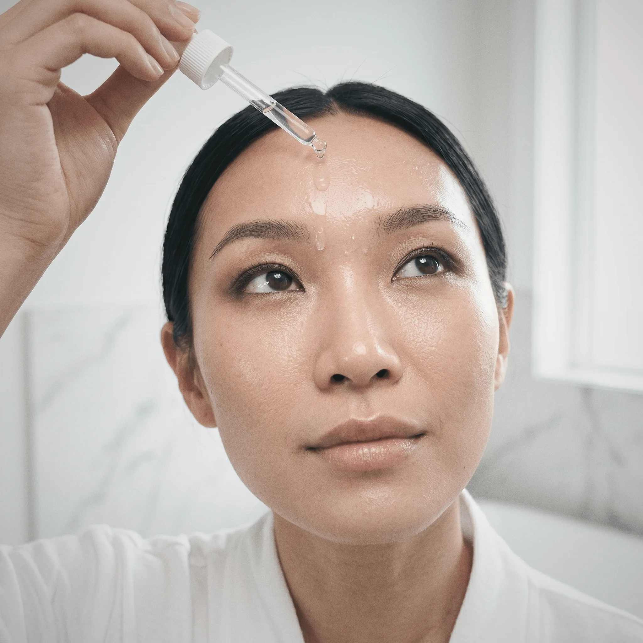 Woman holding Kisuva Hyaluronic Acid Serum close-up