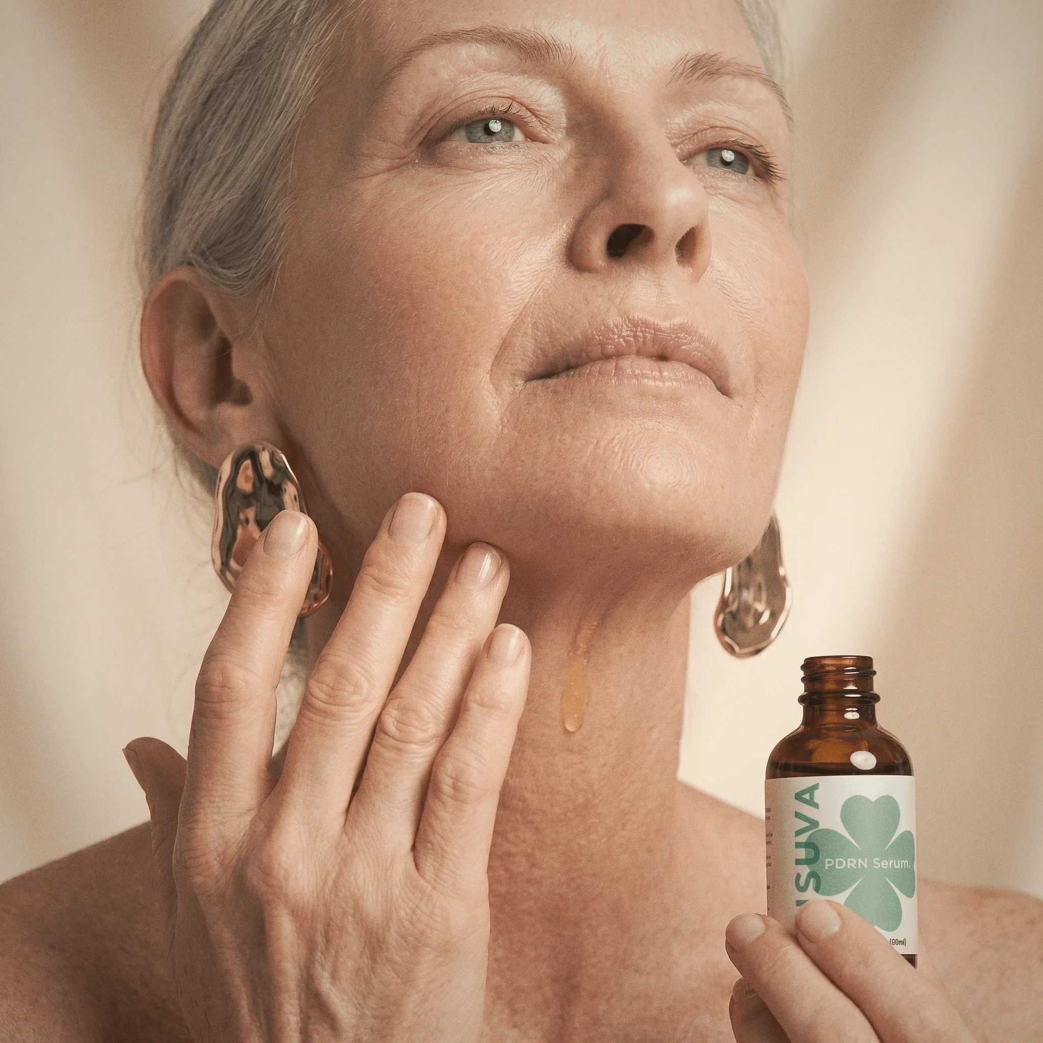 Woman applying Kisuva PDRN Serum to neck