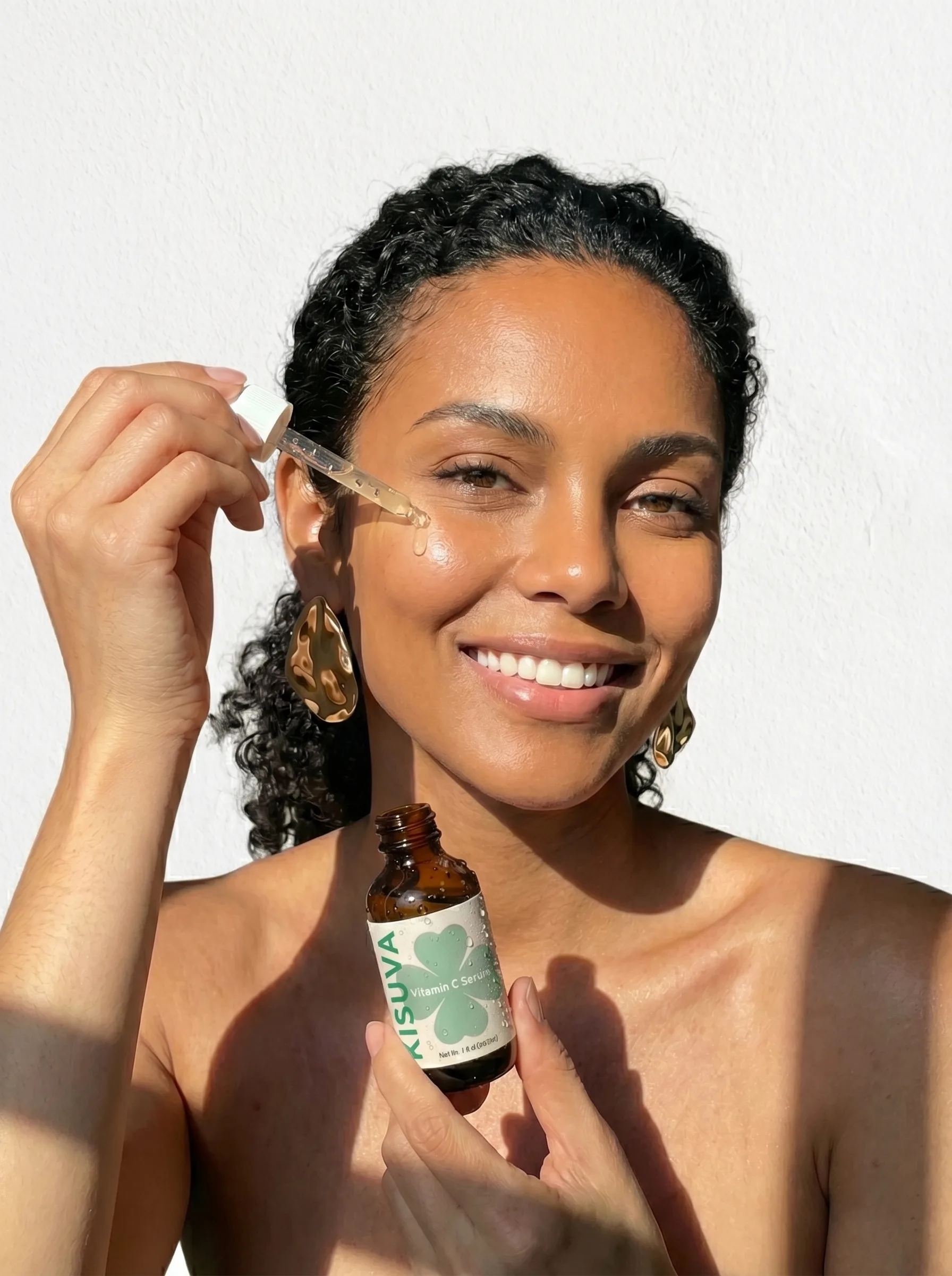 Woman applying Kisuva Vitamin C Serum in sunlight